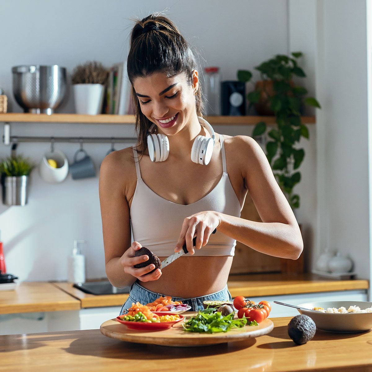 Fitness woman making a healthy poke bowl in the kitchen at home.