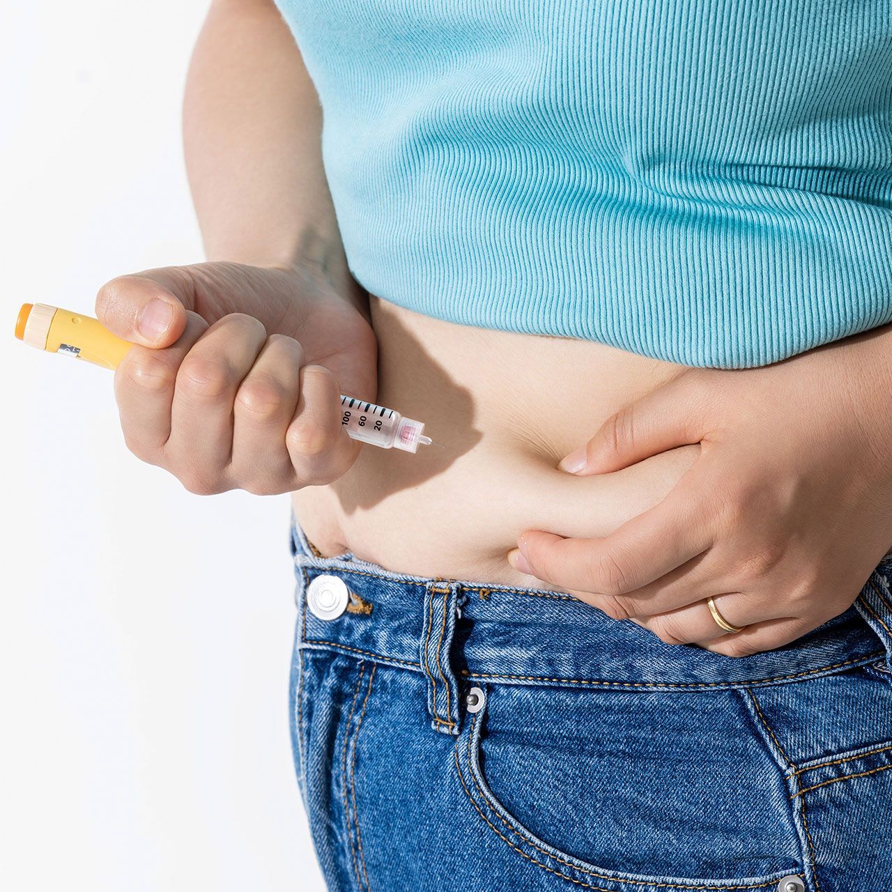 A woman injecting herself with obesity medication