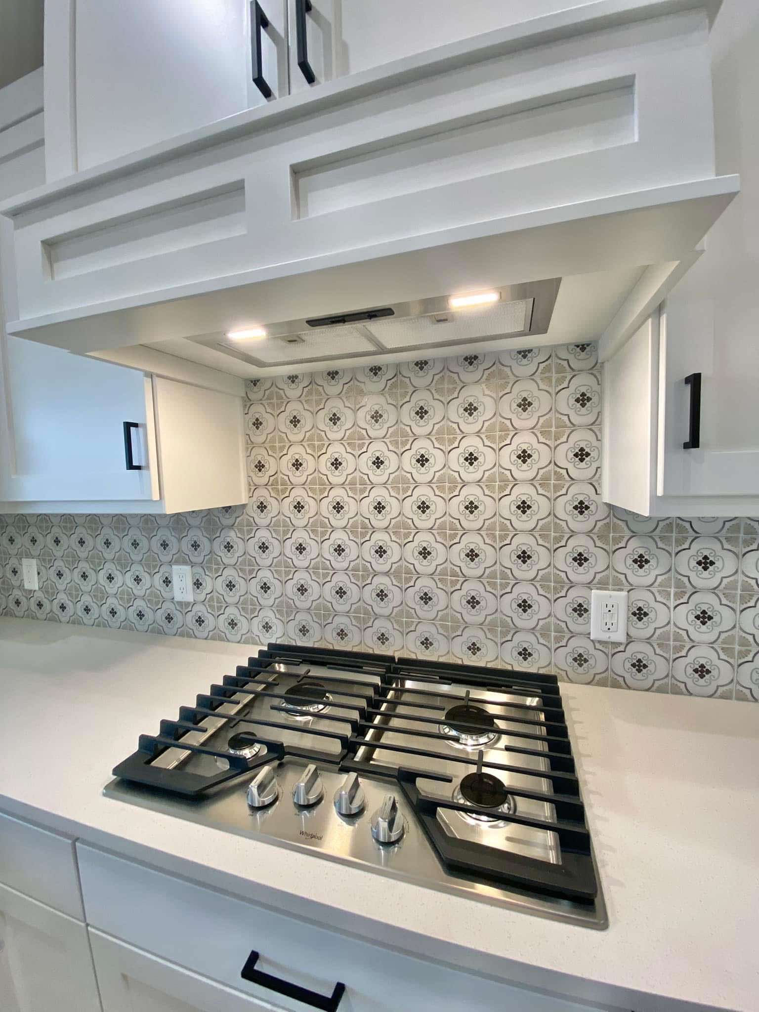 A stove top oven and a white counter from a custom home in Milford