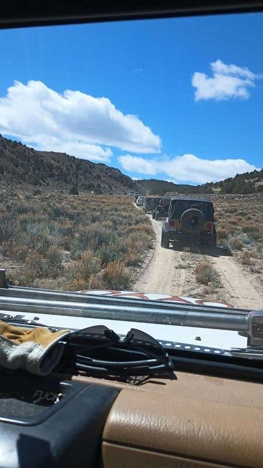 A jeep is driving down a dirt road in the desert.