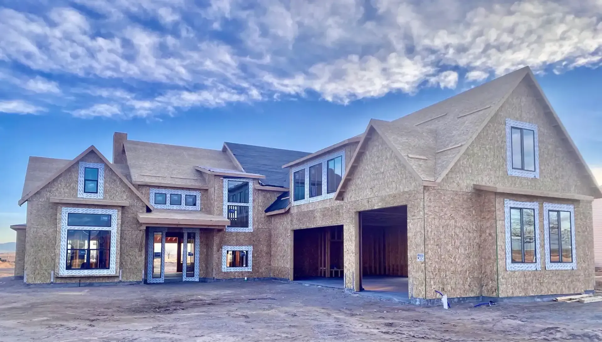 The Ruby, a custom home in milford utah, is being built in the middle of a dirt field.