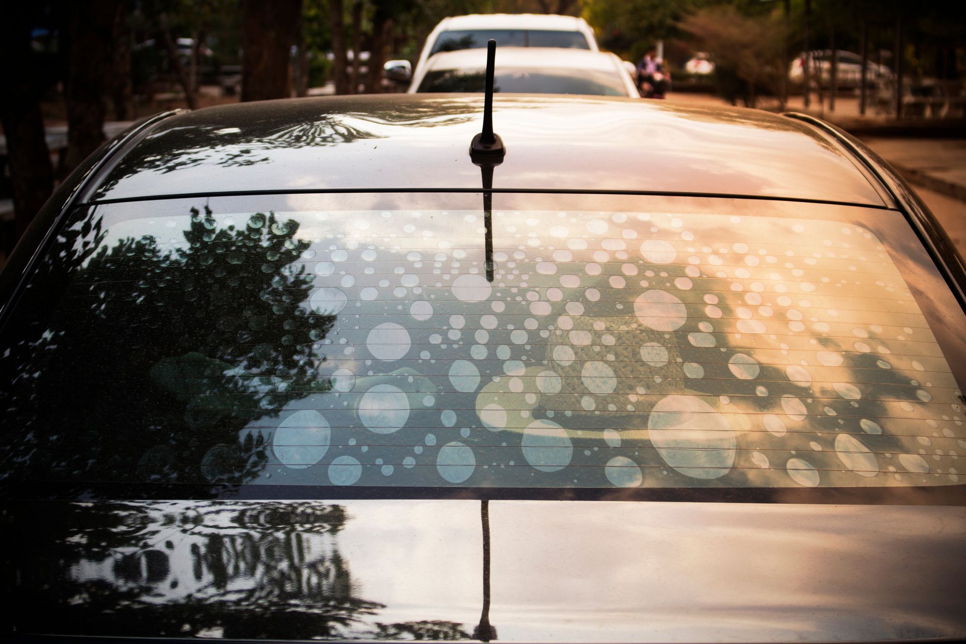 A car with a roof antenna is parked on the side of the road.