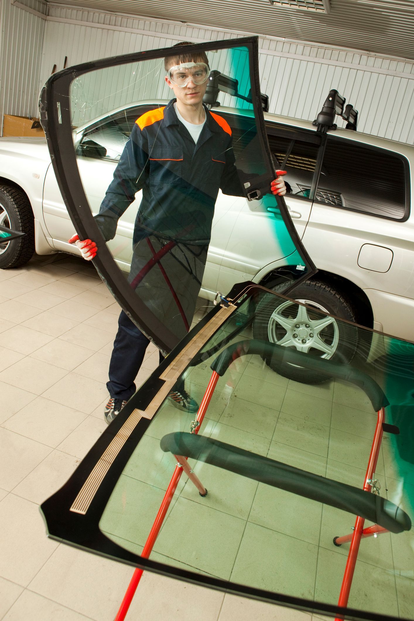A man is installing a windshield on a car.