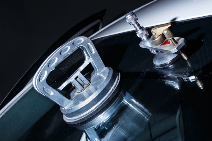 A close up of a car windshield with a vacuum on it.