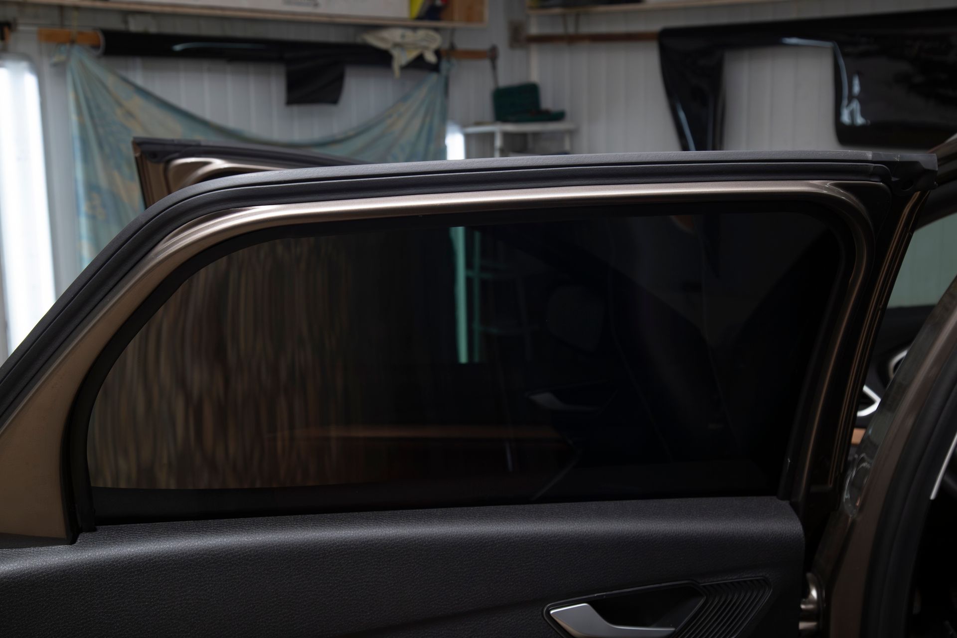A car is parked in a garage with the door open.