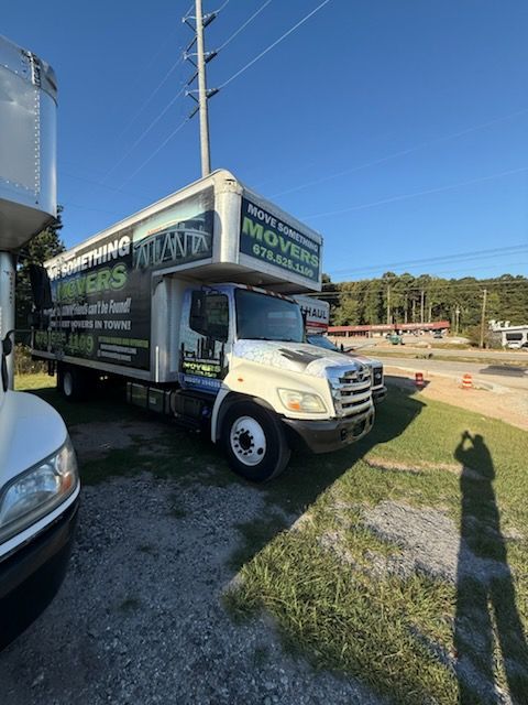 Moving truck parked outdoors on a sunny day; company logo visible.