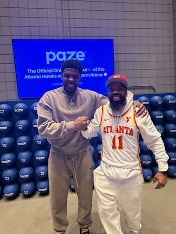 Two men shaking hands in front of a blue 