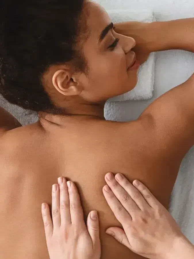 A woman is getting a massage on her back at a spa.