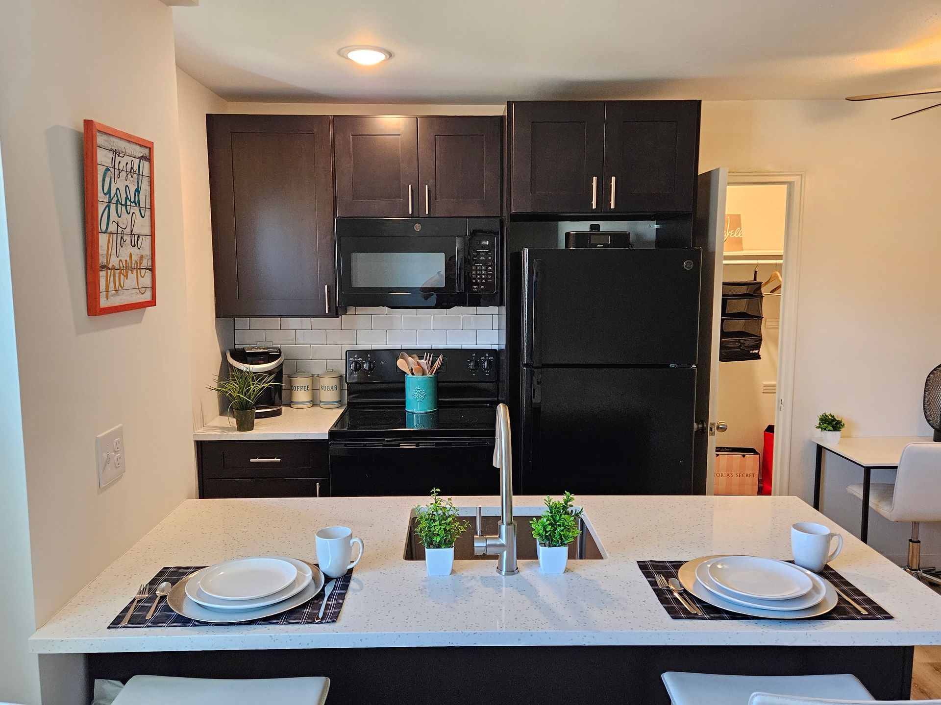 A kitchen with a black refrigerator and a white counter top
