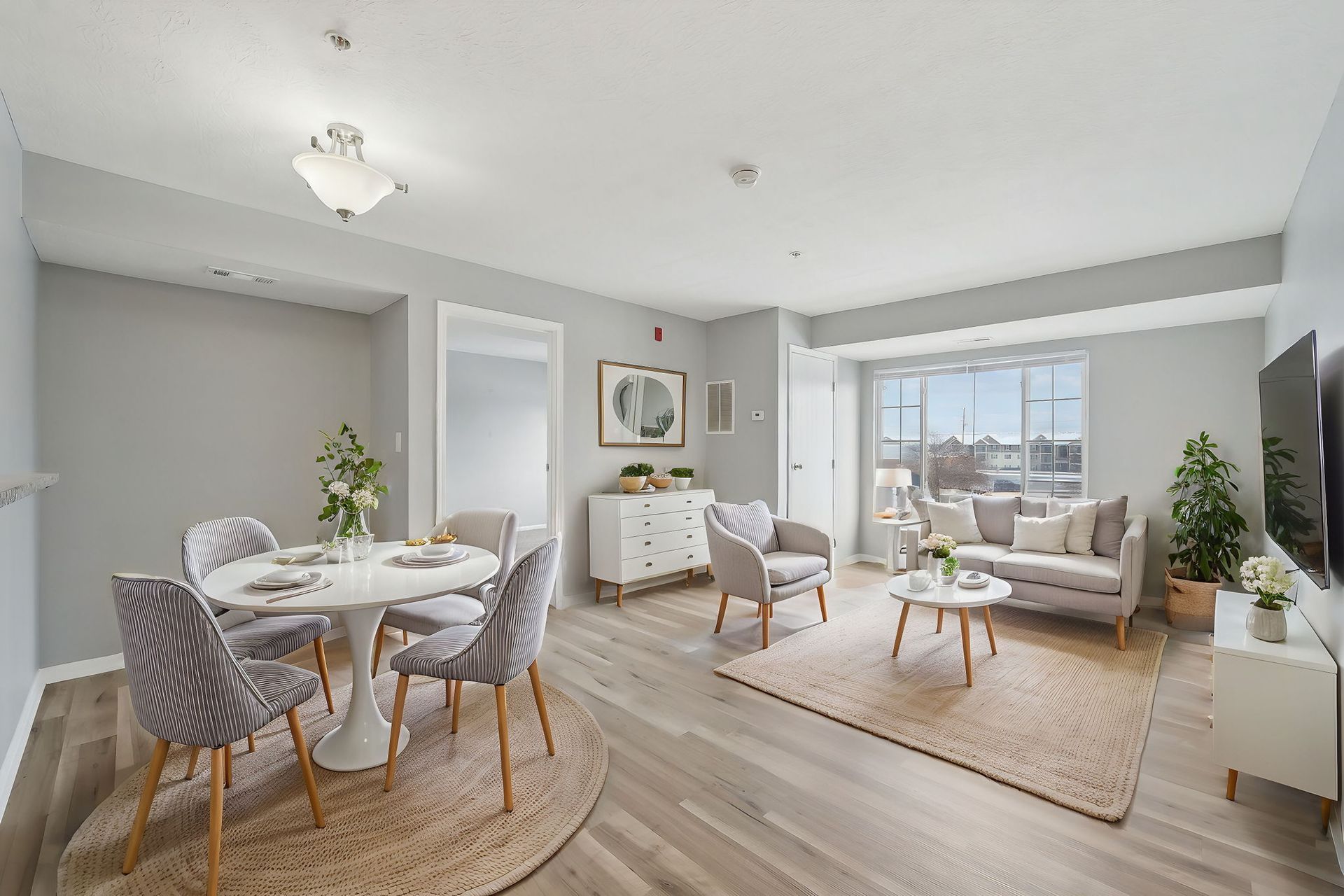 A living room with a couch , chairs , a table and a television.