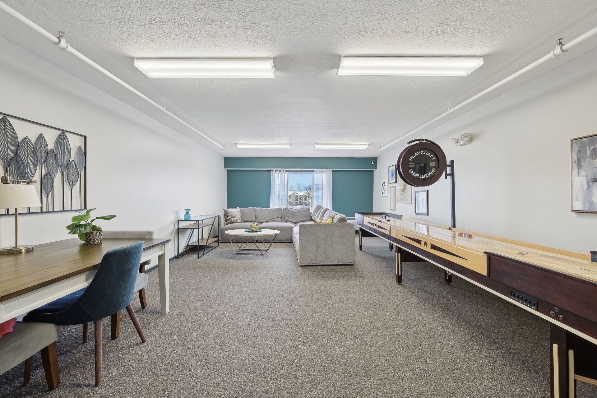 There is a shuffleboard table in the middle of the room.