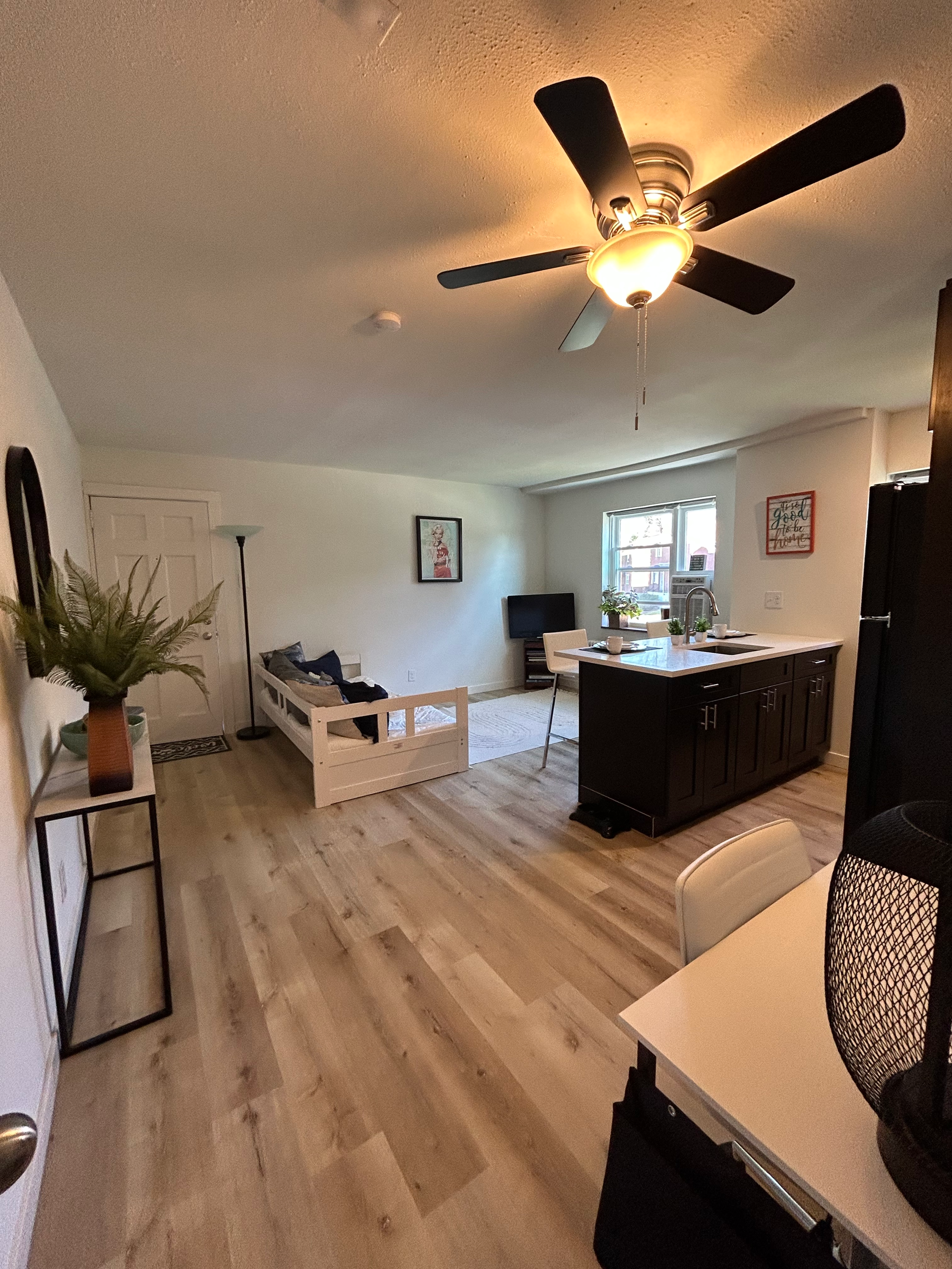 A living room with hardwood floors and a ceiling fan.
