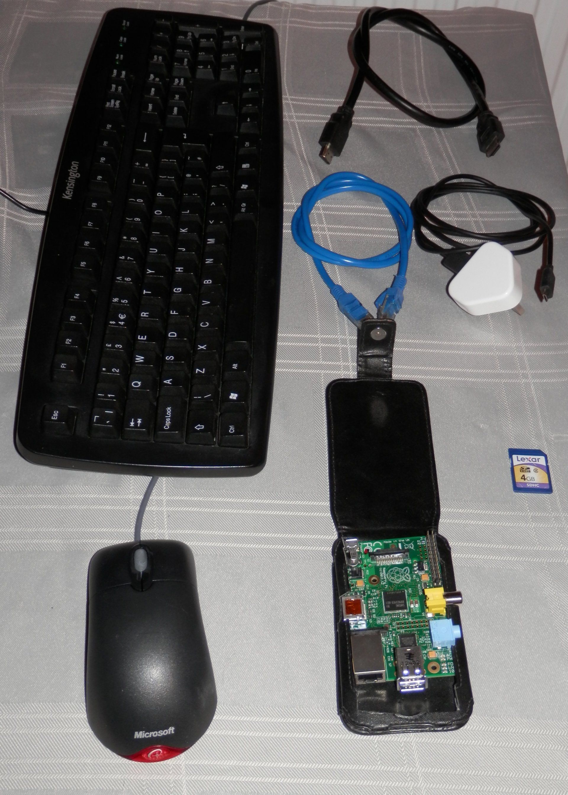 A keyboard a mouse and a raspberry pi are on a table