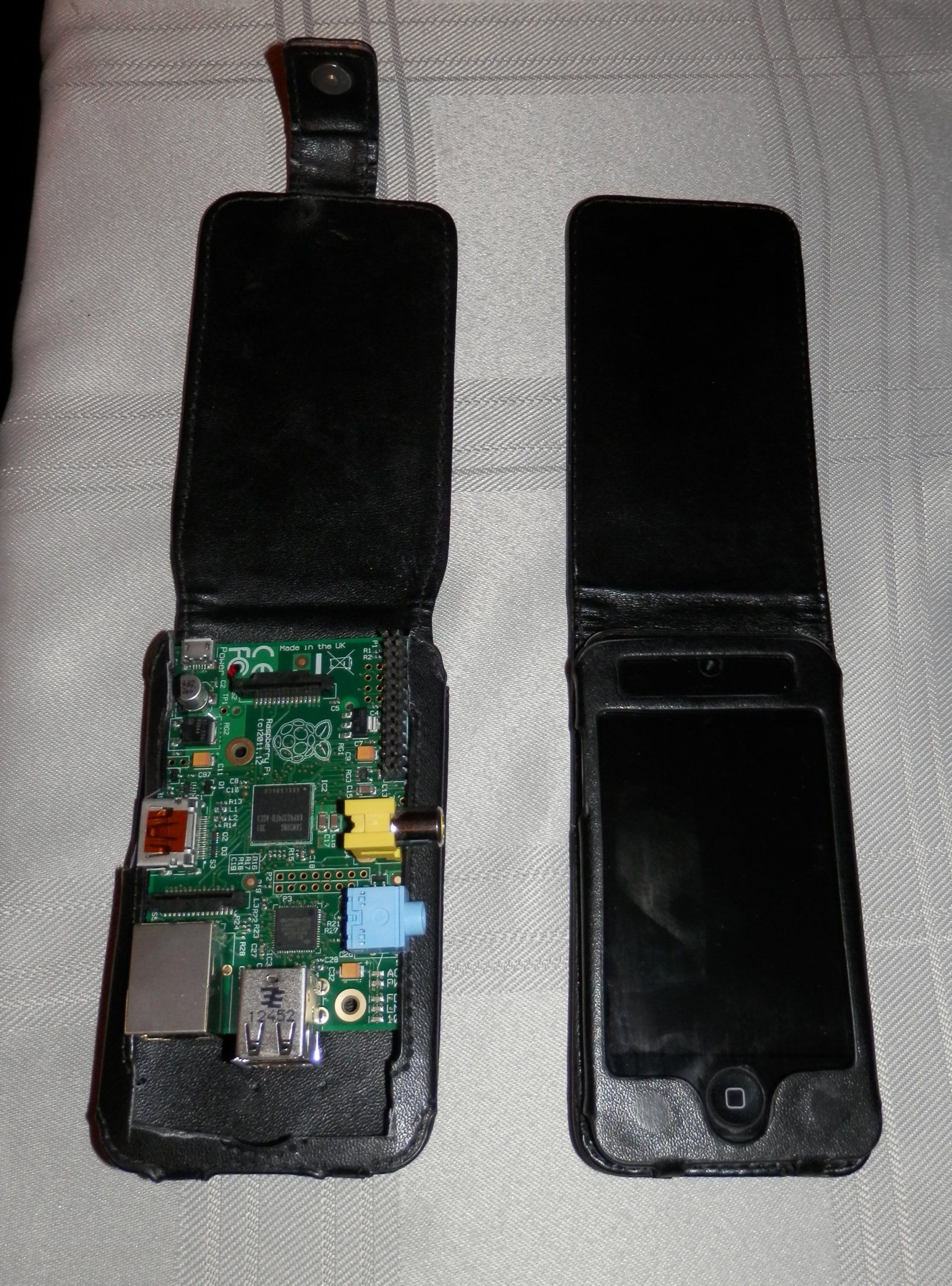 Two cell phones are laying side by side on a table