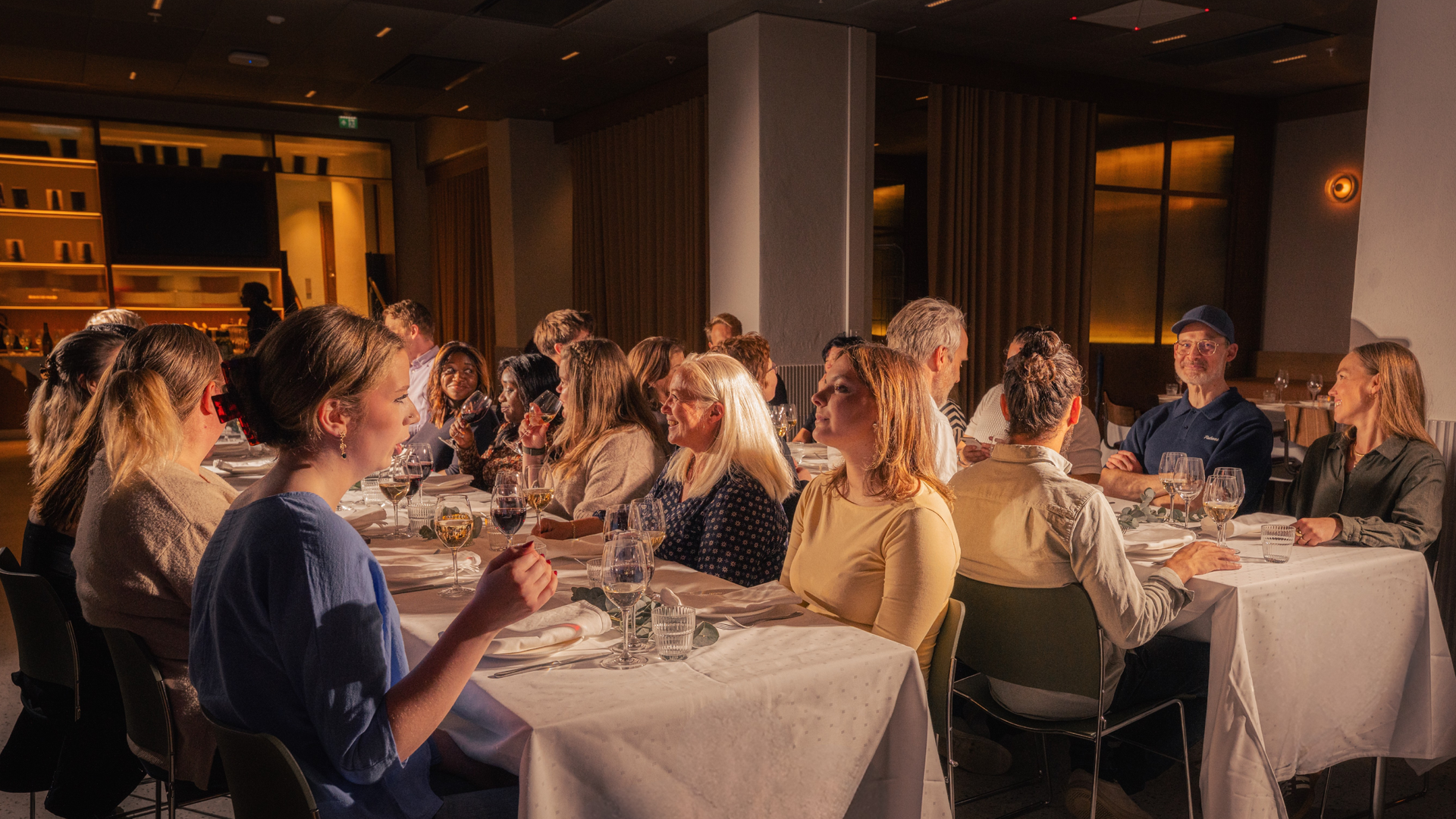 Tomme, varmt opplyste restaurantbåsseter med trepanelvegger og pendellamper