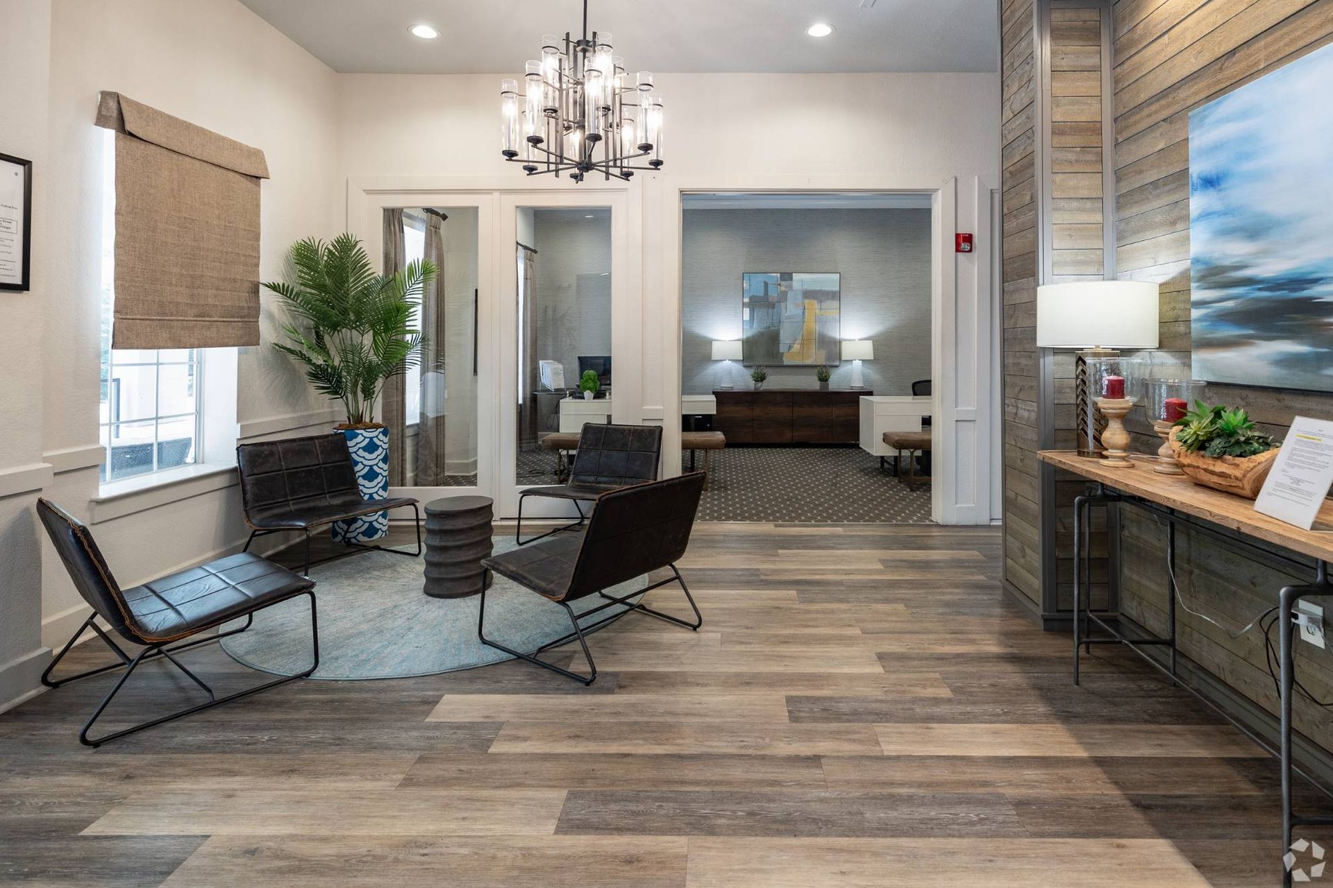 Leasing office lobby with seating, chandelier, and wood-accent walls.
