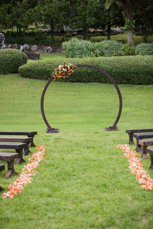 A Wedding Ceremony Is Taking Place In A Park With A Circular Arch - Honolulu, HI - Bella Rosa Corporation