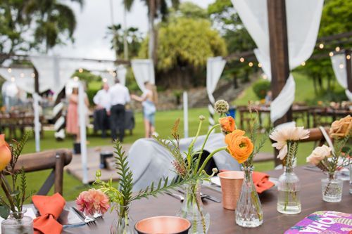 A Table Set For A Wedding Reception With Flowers In Vases On It - Honolulu, HI - Bella Rosa Corporation