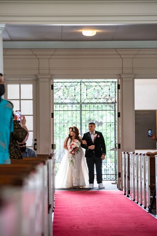 A Bride And Groom Are Walking Down The Aisle Of A Church - Honolulu, HI - Bella Rosa Corporation