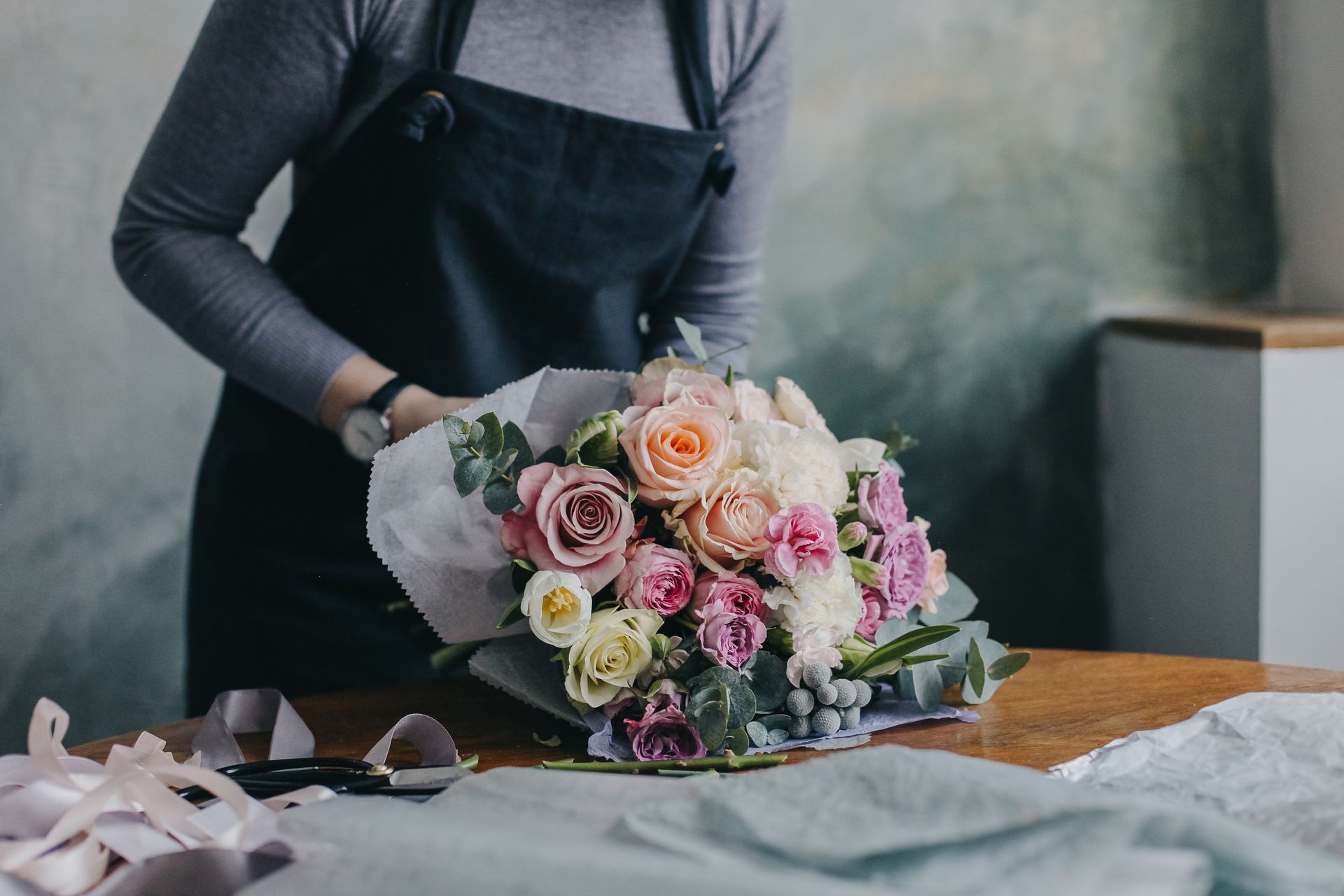 A florist is arranging a bouquet. A florist is arranging a bouquet.