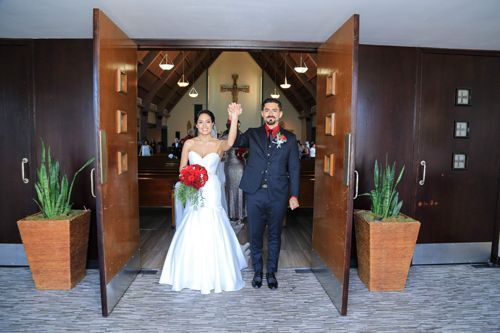 A Bride And Groom Are Standing In Front Of A Church Holding Hands - Honolulu, HI - Bella Rosa Corporation