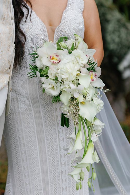 A Bride In A White Dress Is Holding A Bouquet Of White Flowers - Honolulu, HI - Bella Rosa Corporation