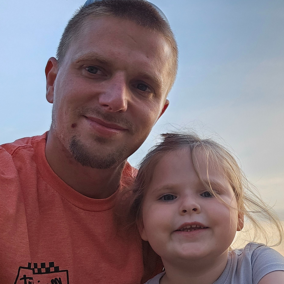 A man and a little girl are posing for a picture together.