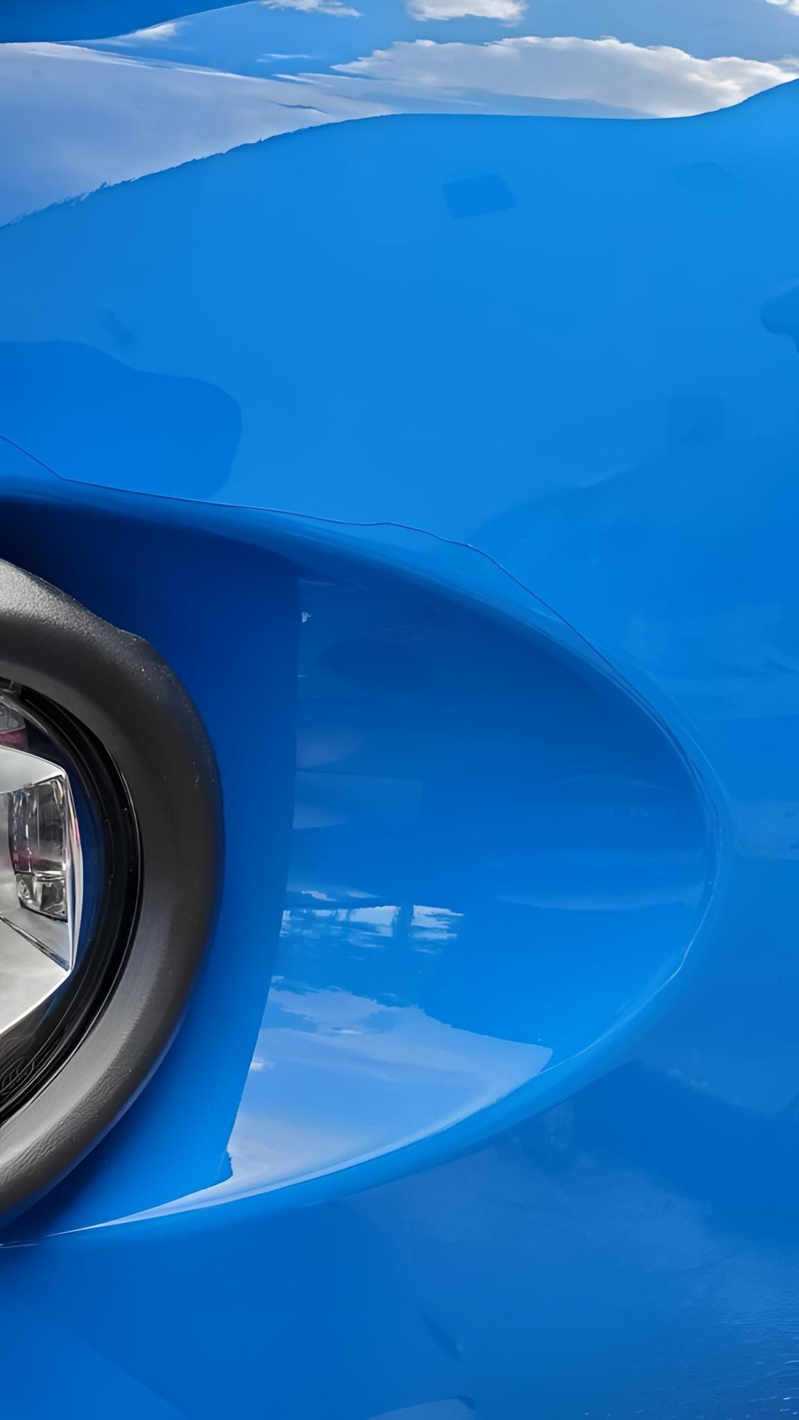 A close up of the front bumper of a blue car.