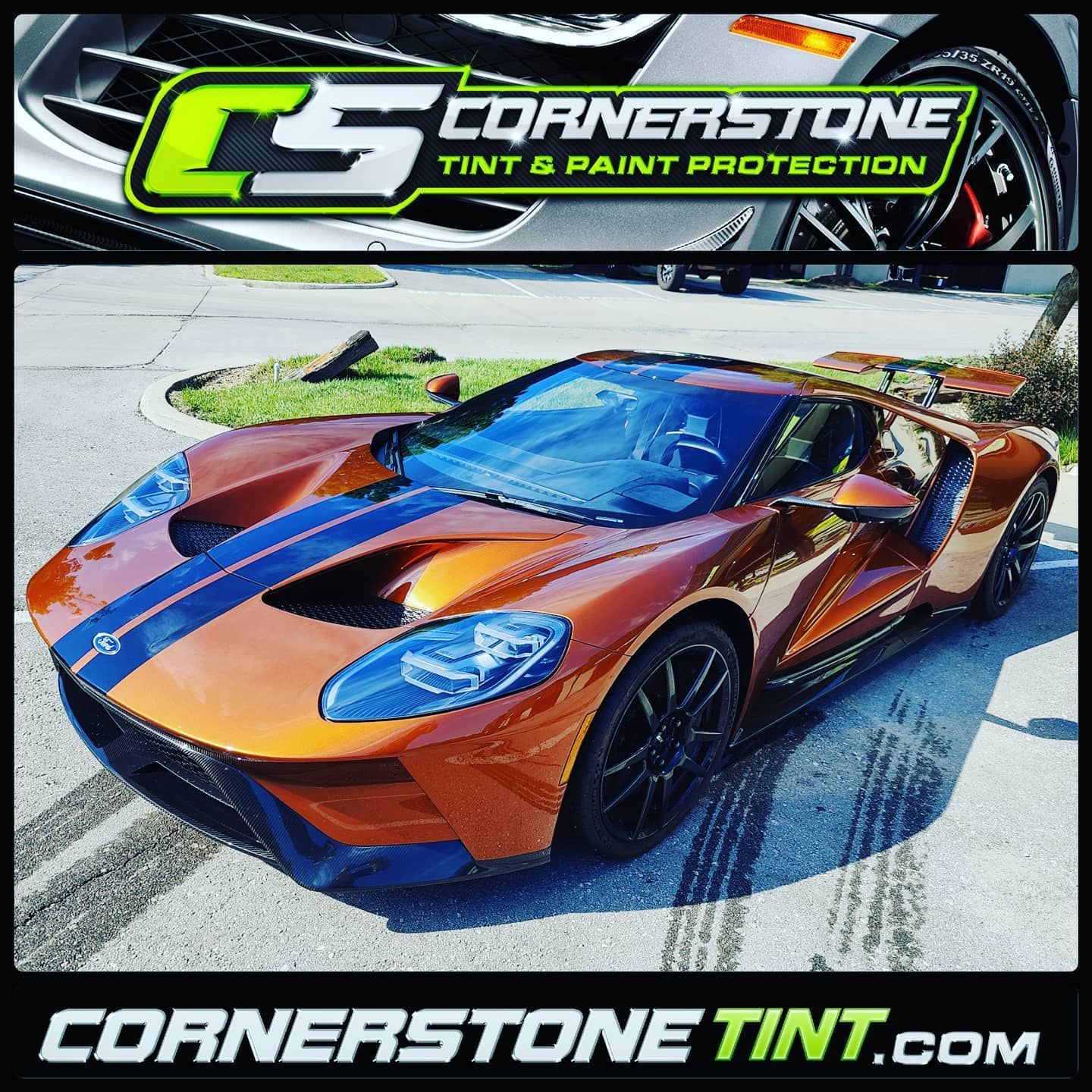 An orange sports car is parked on the side of the road.