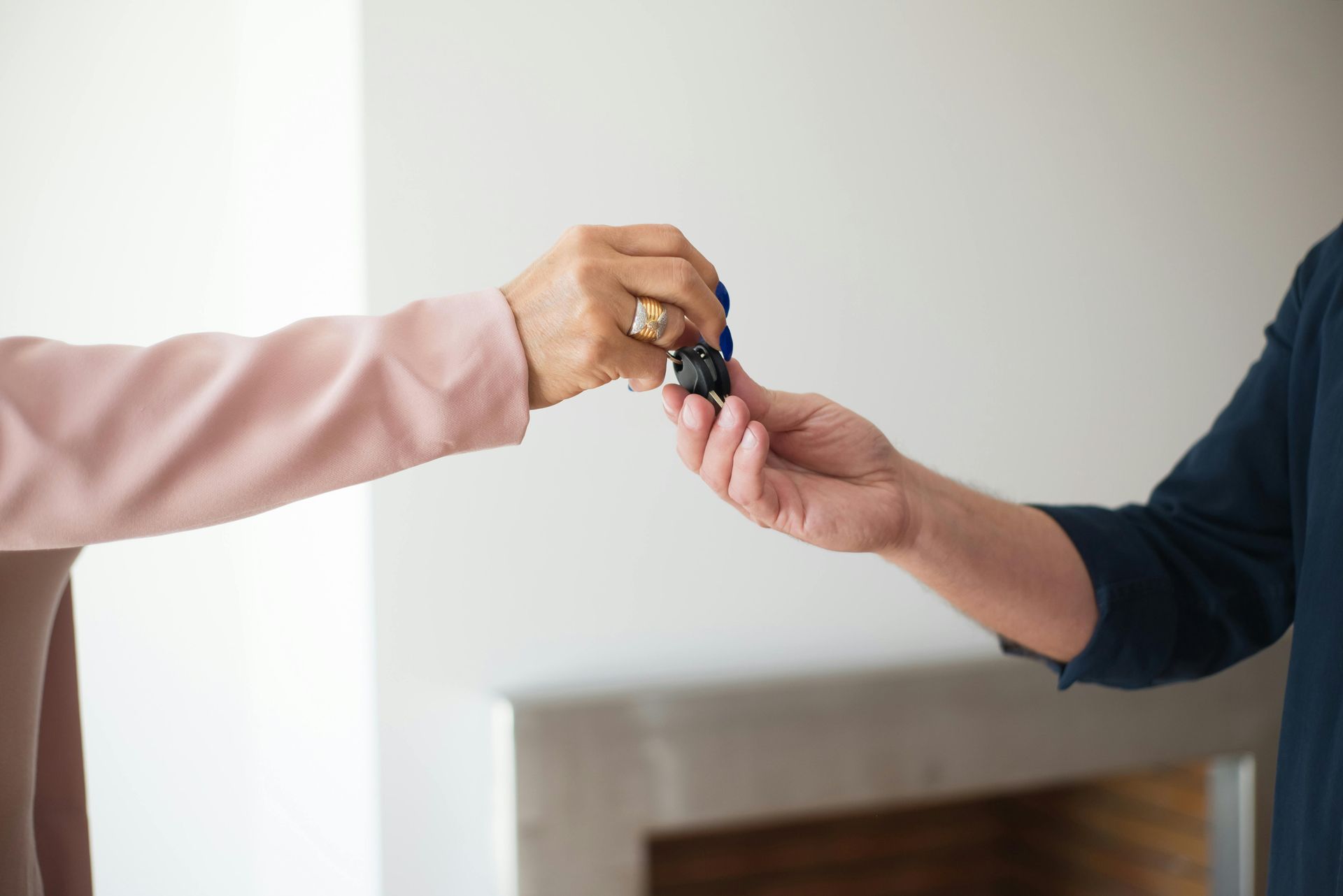 A person is handing a car key to another person.
