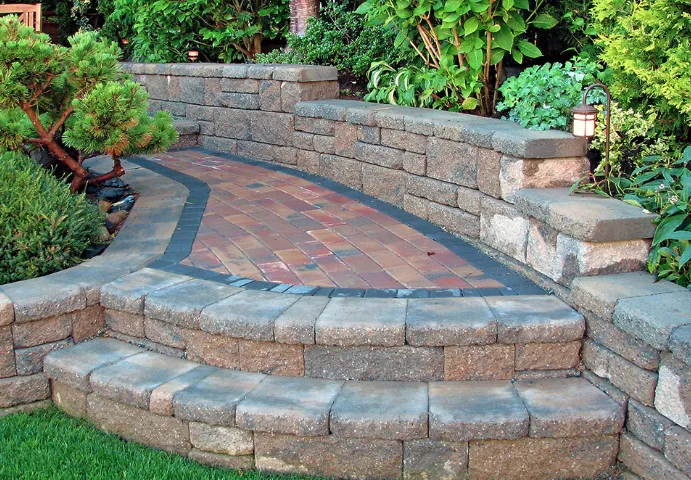 A stone wall with steps leading up to it in a garden