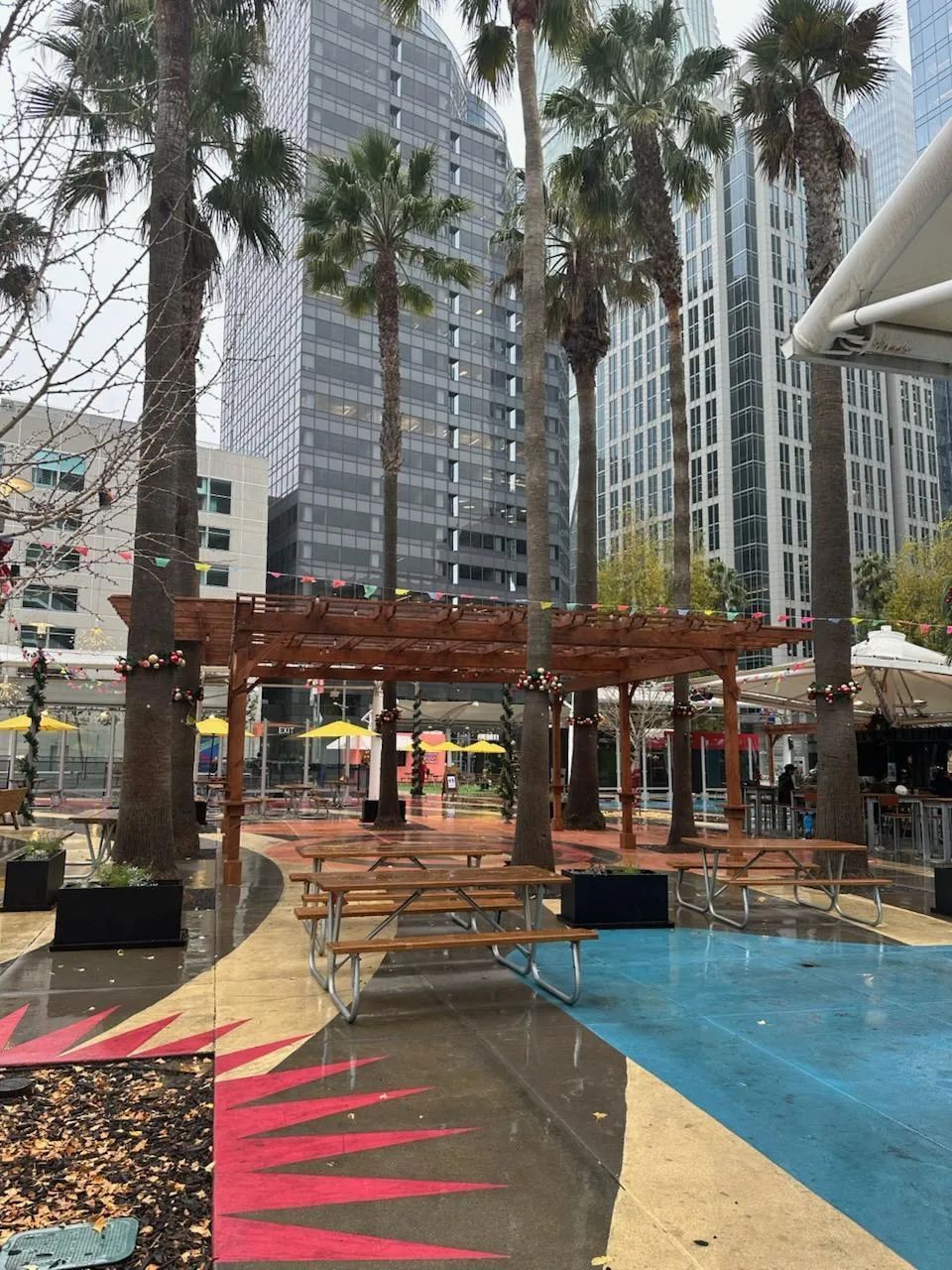 A picnic area in a city with palm trees and umbrellas