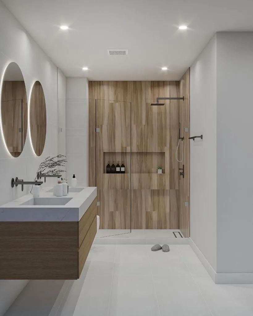 A bathroom with two sinks , a mirror and a shower.