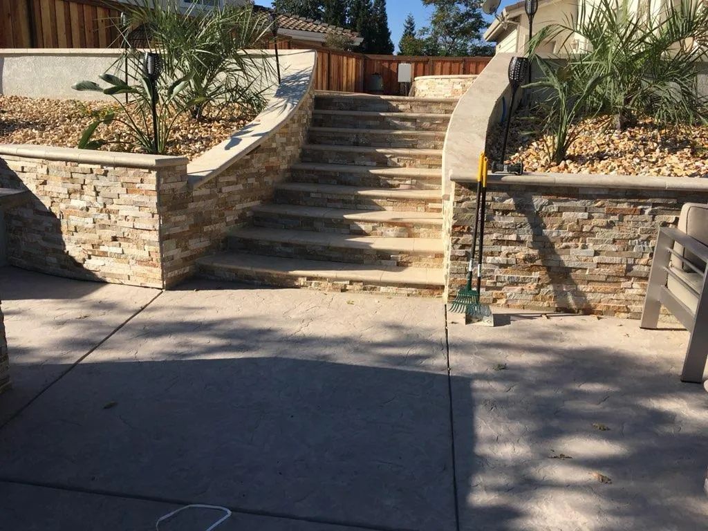 A stone wall with stairs leading up to a house
