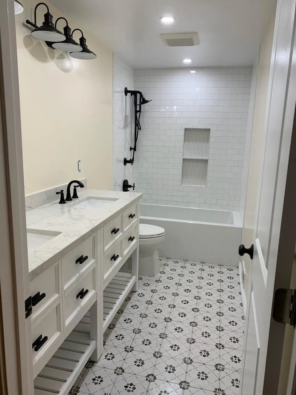 A bathroom with two sinks , a toilet , and a bathtub.
