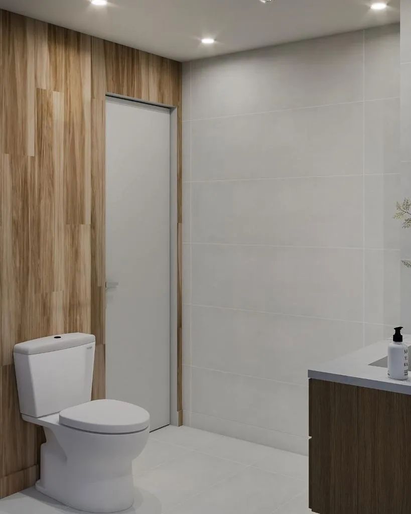 A bathroom with a toilet , sink , and wooden walls.