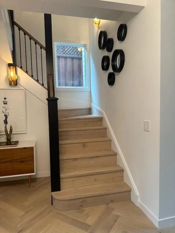 A staircase with a black railing and wooden steps