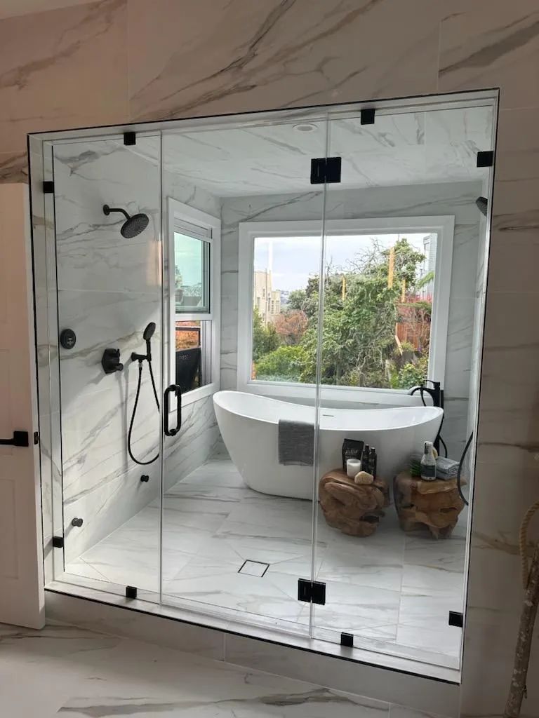 A bathroom with a tub , shower , and window.