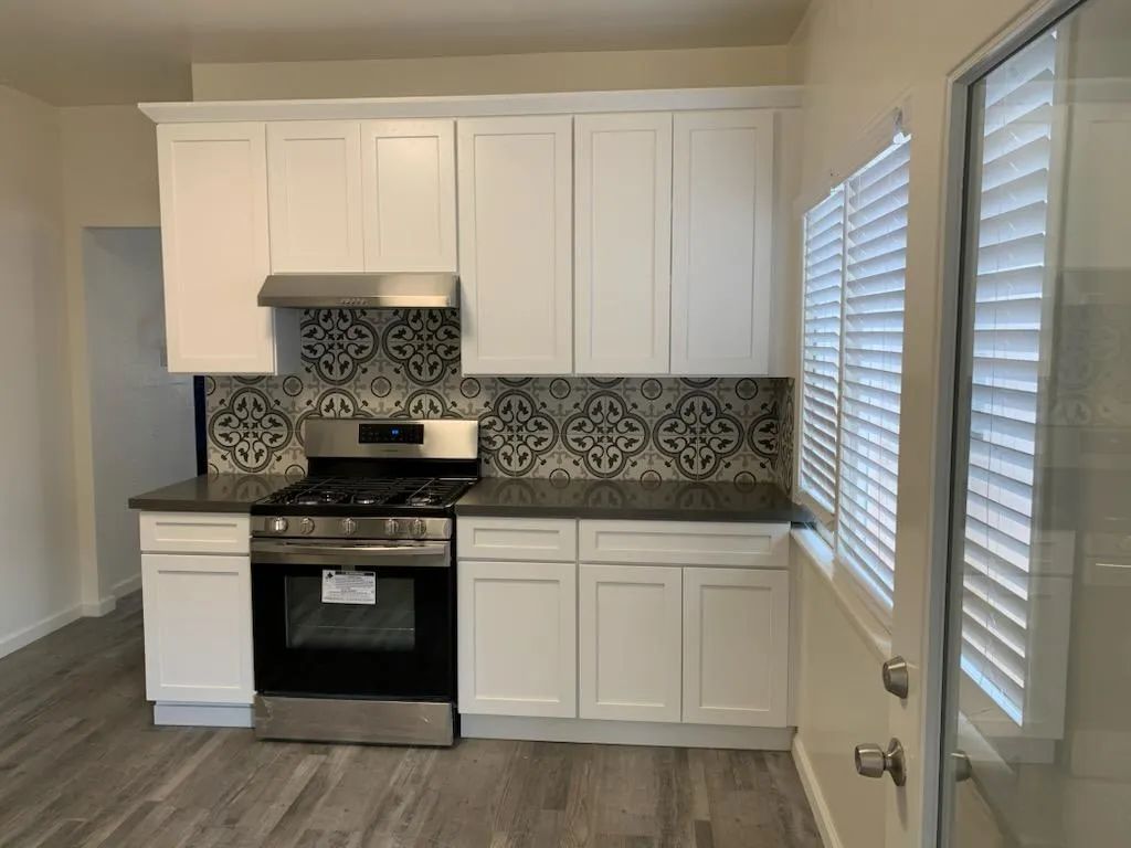 A kitchen with white cabinets and stainless steel appliances