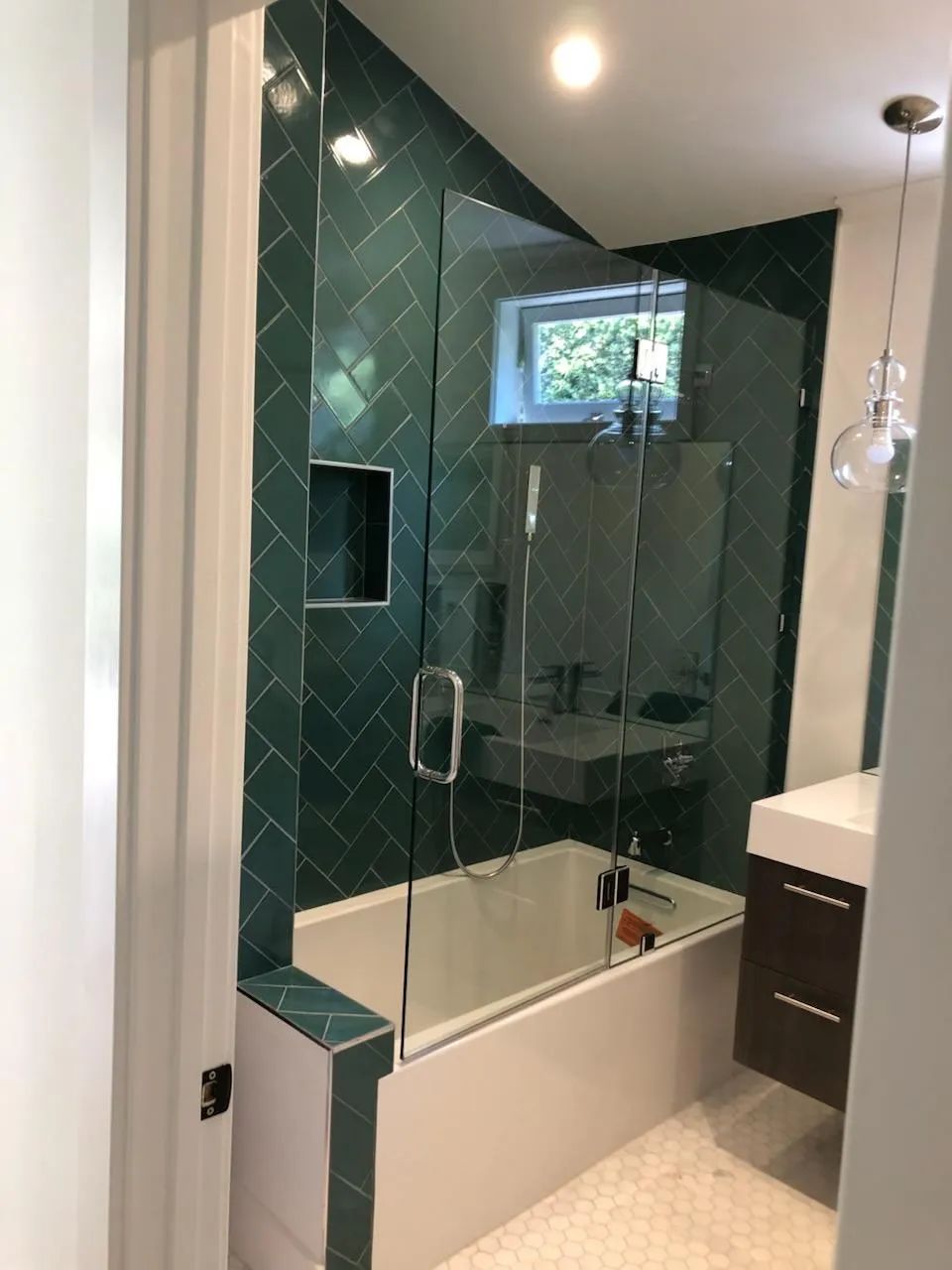 A bathroom with a bathtub and a glass shower door