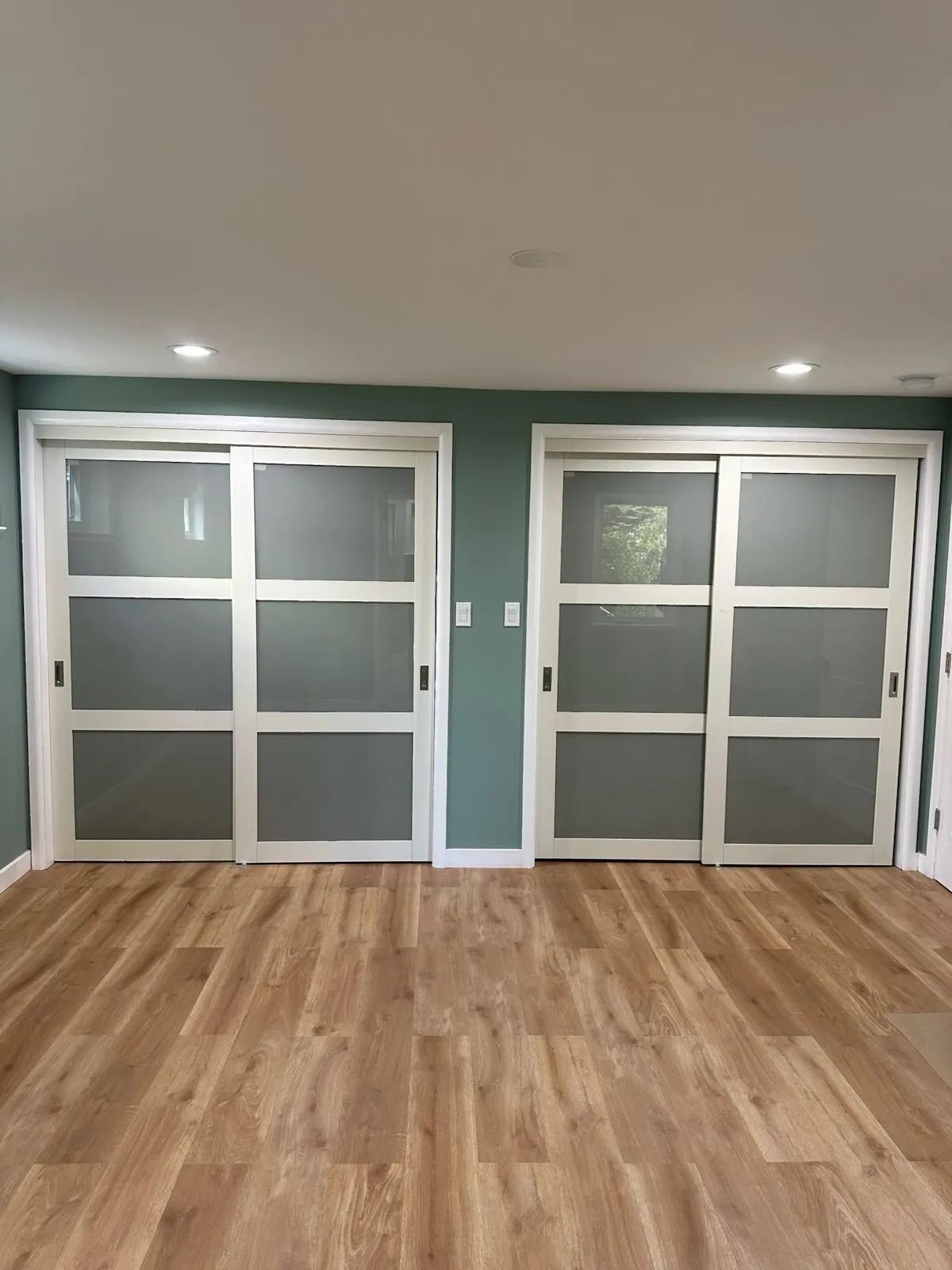 A living room with hardwood floors and sliding glass doors.
