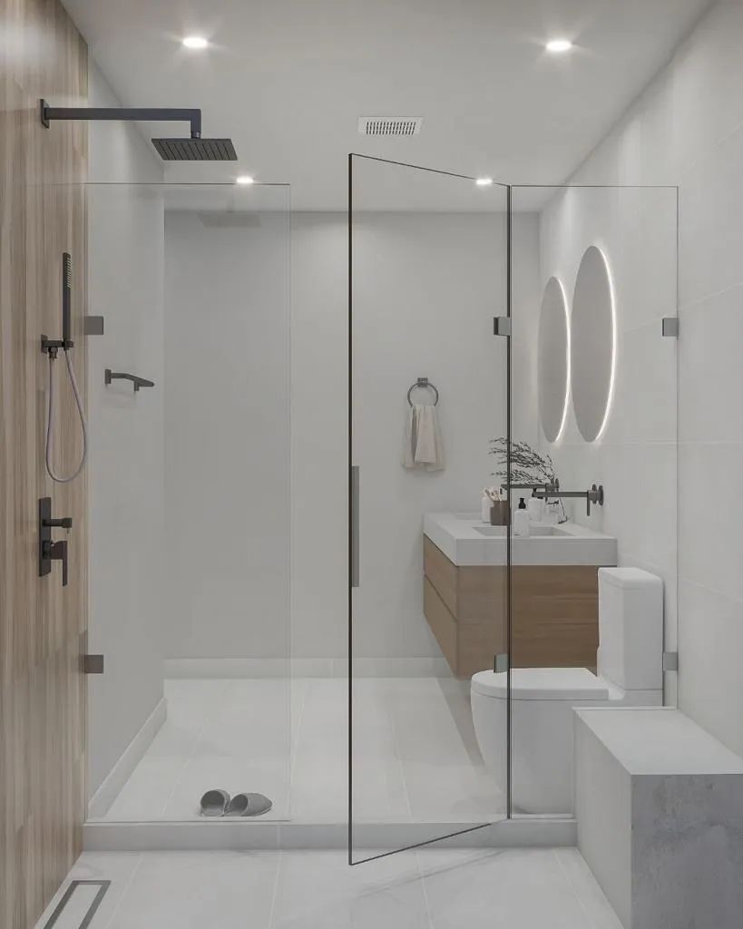 A bathroom with a walk in shower , sink , toilet and mirror.