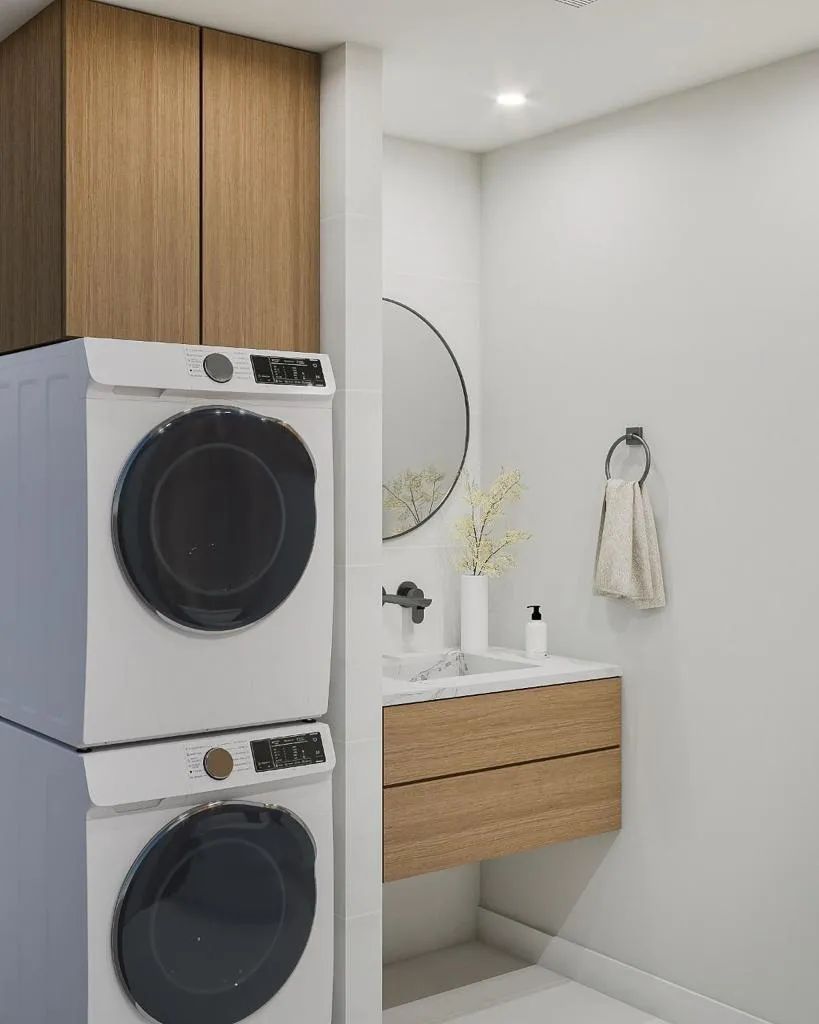 A bathroom with a washer and dryer stacked on top of each other.