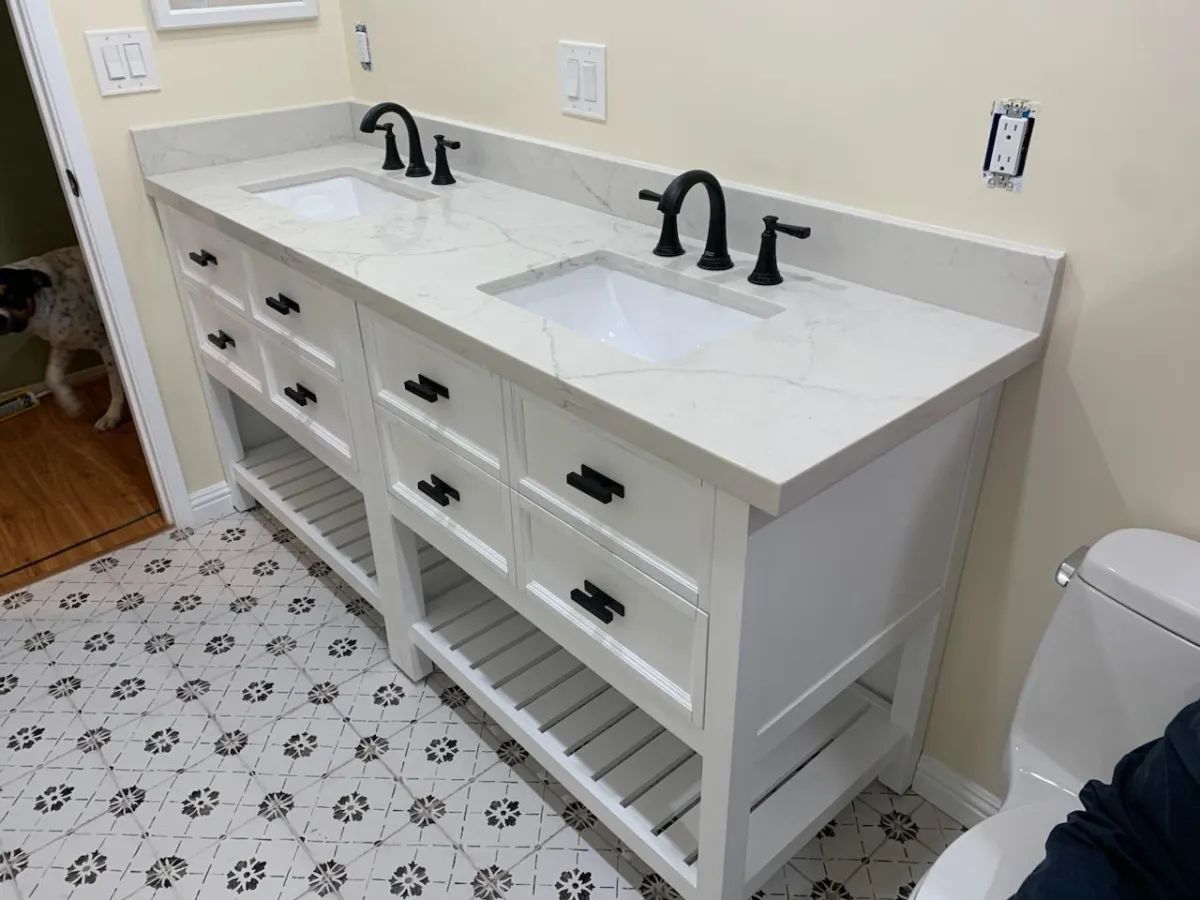 A bathroom with two sinks and a toilet.