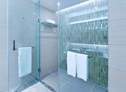 A bathroom with a walk in shower and a sink.