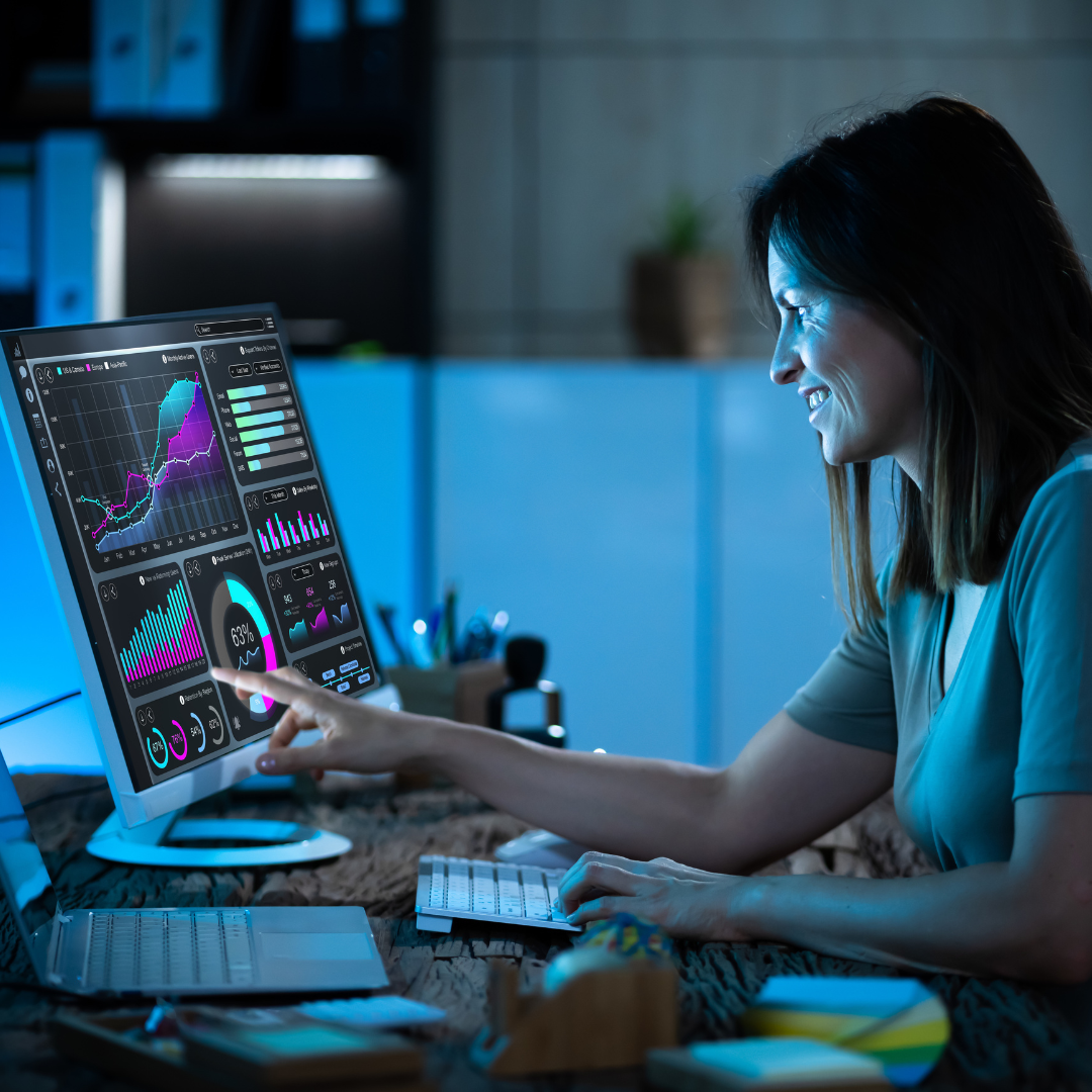 A woman is sitting at a desk working on a computer.