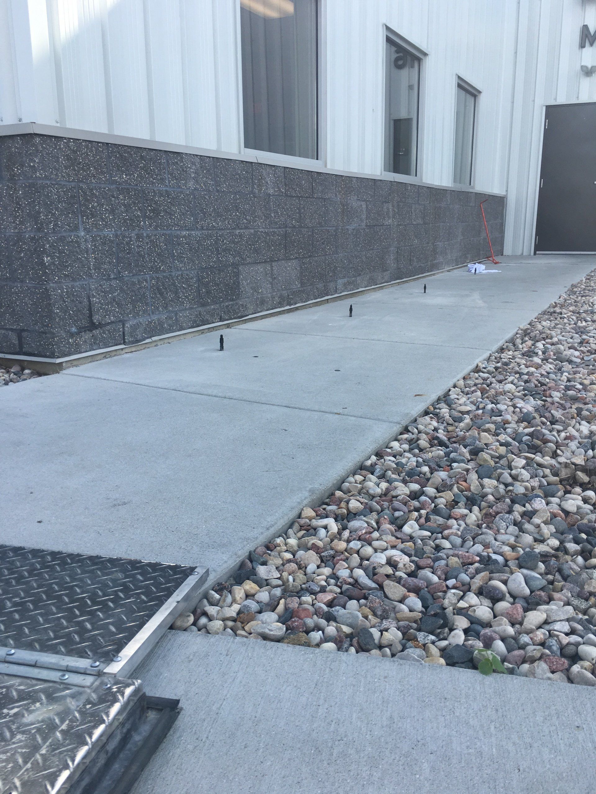 A concrete walkway with a ramp in front of a building