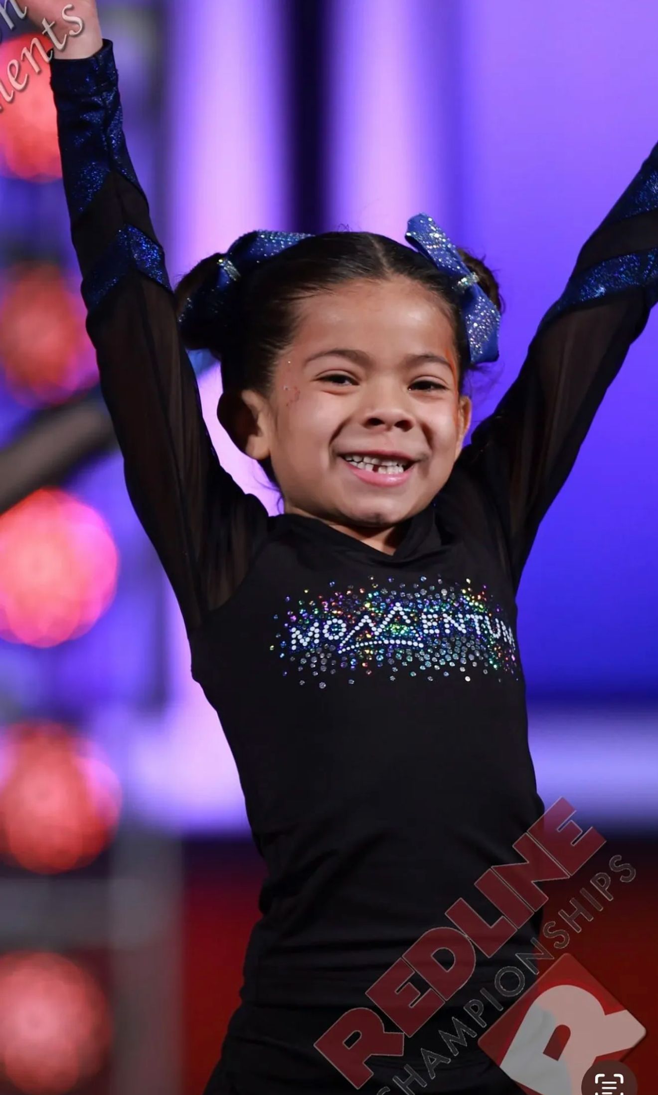 A preschool age cheerleaderl doing a simple stunt at a local competition