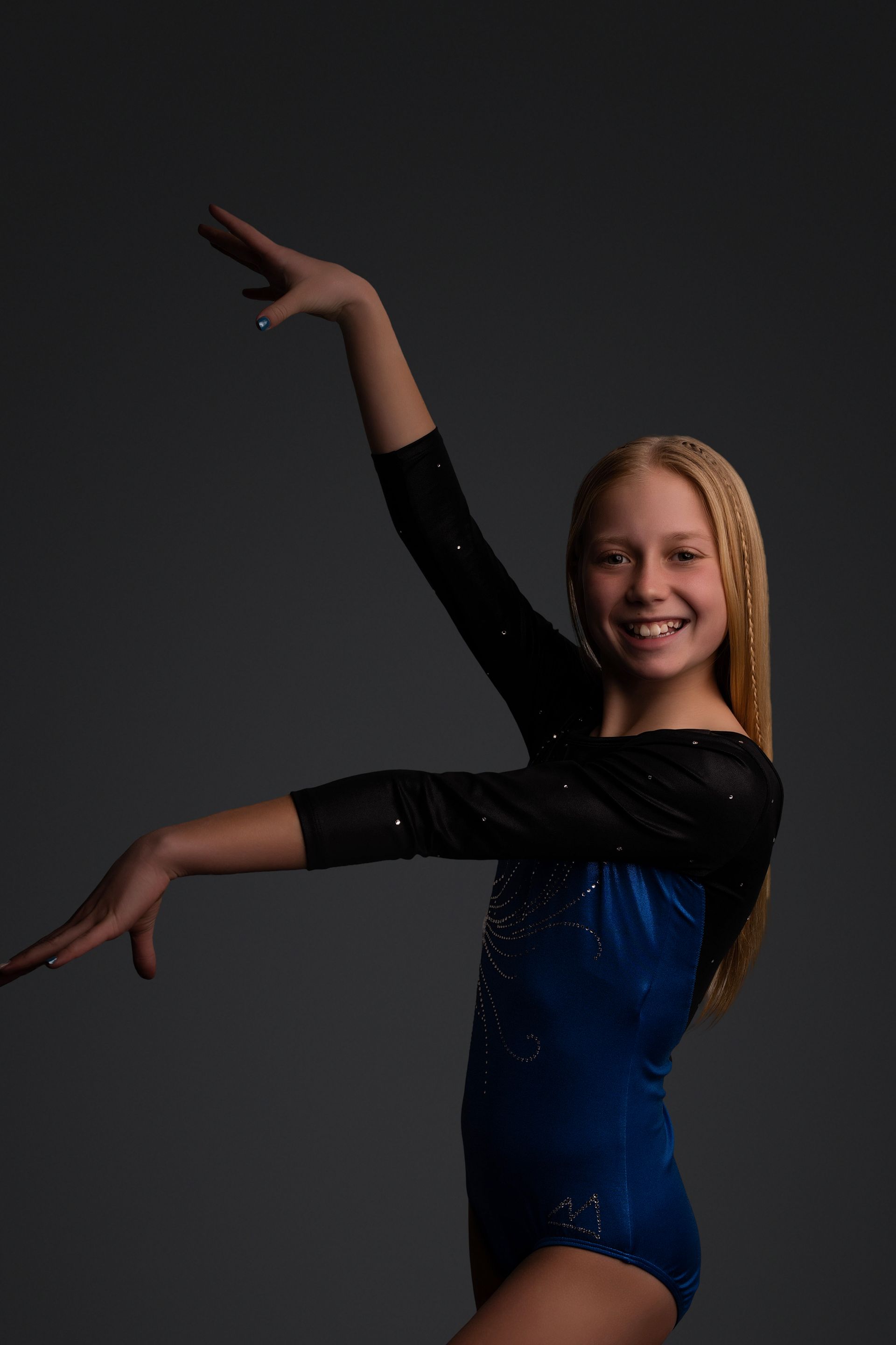 A female gymnast is balancing on a balance beam.