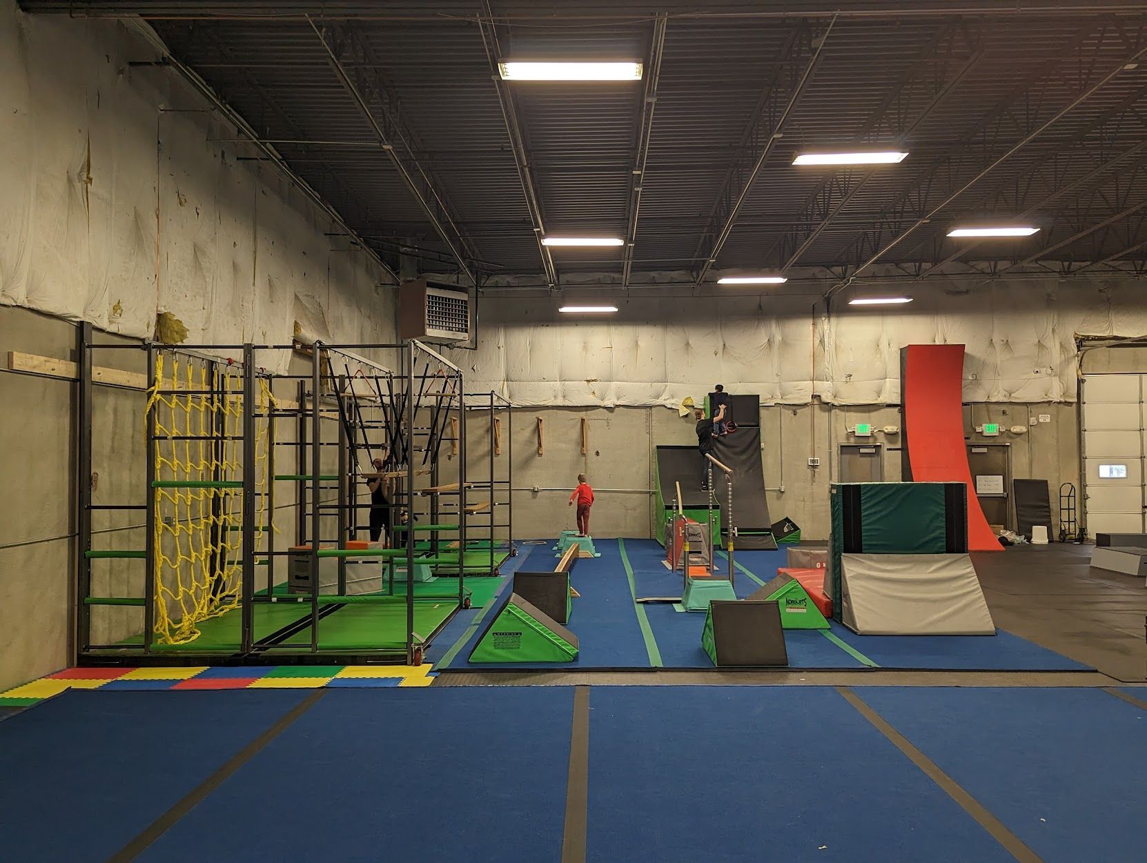 A gym with a lot of equipment and a blue floor.